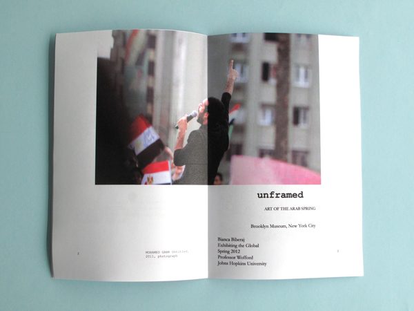 The catalog has been opened to reveal a full size page of a man outside speaking into a microphone with the title "unframed".