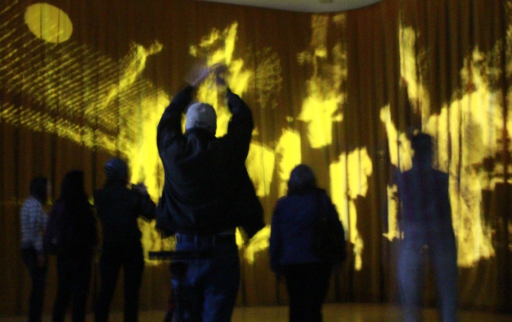 The silhouette of a few people dancing in front of a stage.