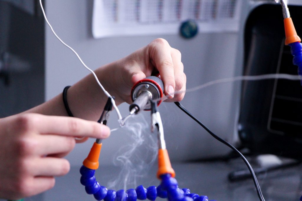 Student soldering a tool in the Maker Space