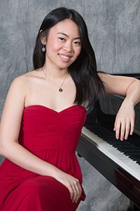 Stephanie Cai sitting in front of a piano.