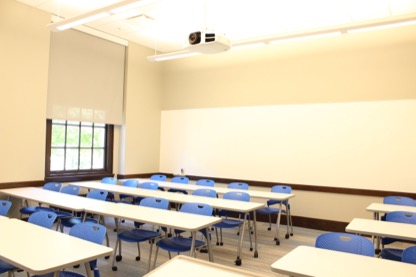 Empty Krieger 306 classroom showing table and chair configuration. 