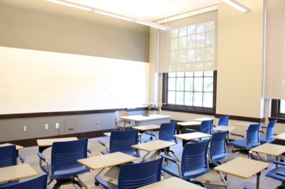 Empty Krieger 300 classroom showing individual desk and chair seating.