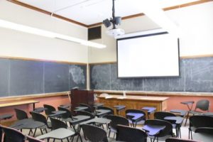 Empty classroom showing individual desk and chair seating.