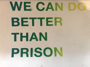 green and yellow screenprint reading "WE CAN DO BETTER THAN PRISON"
