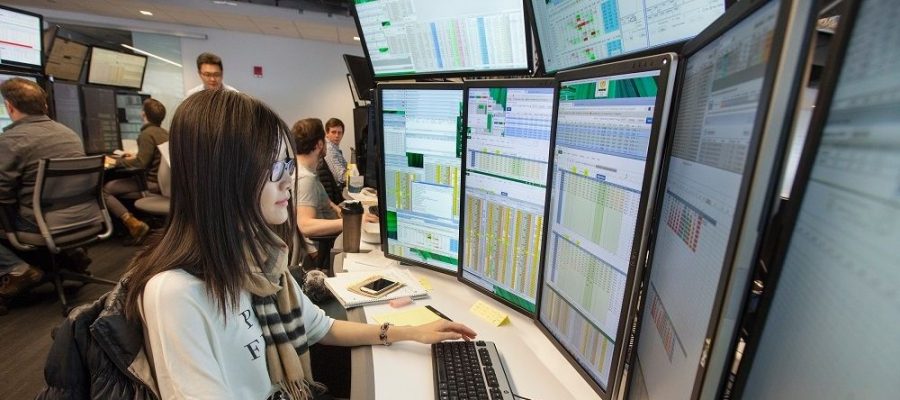 Female staff member in front of trading screens at Akuna Capital