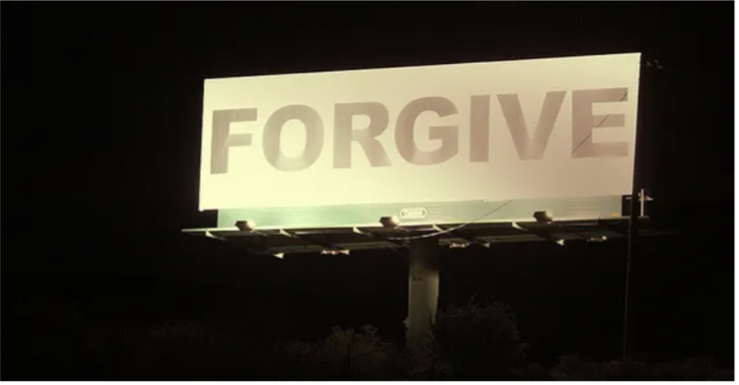 Illuminated sign that reads "Forgive."