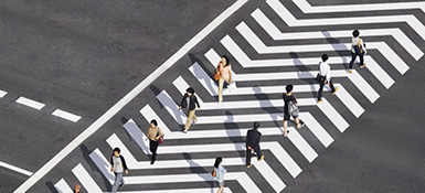 An aerial photo of a group of people crossing the street in a crosswalk
