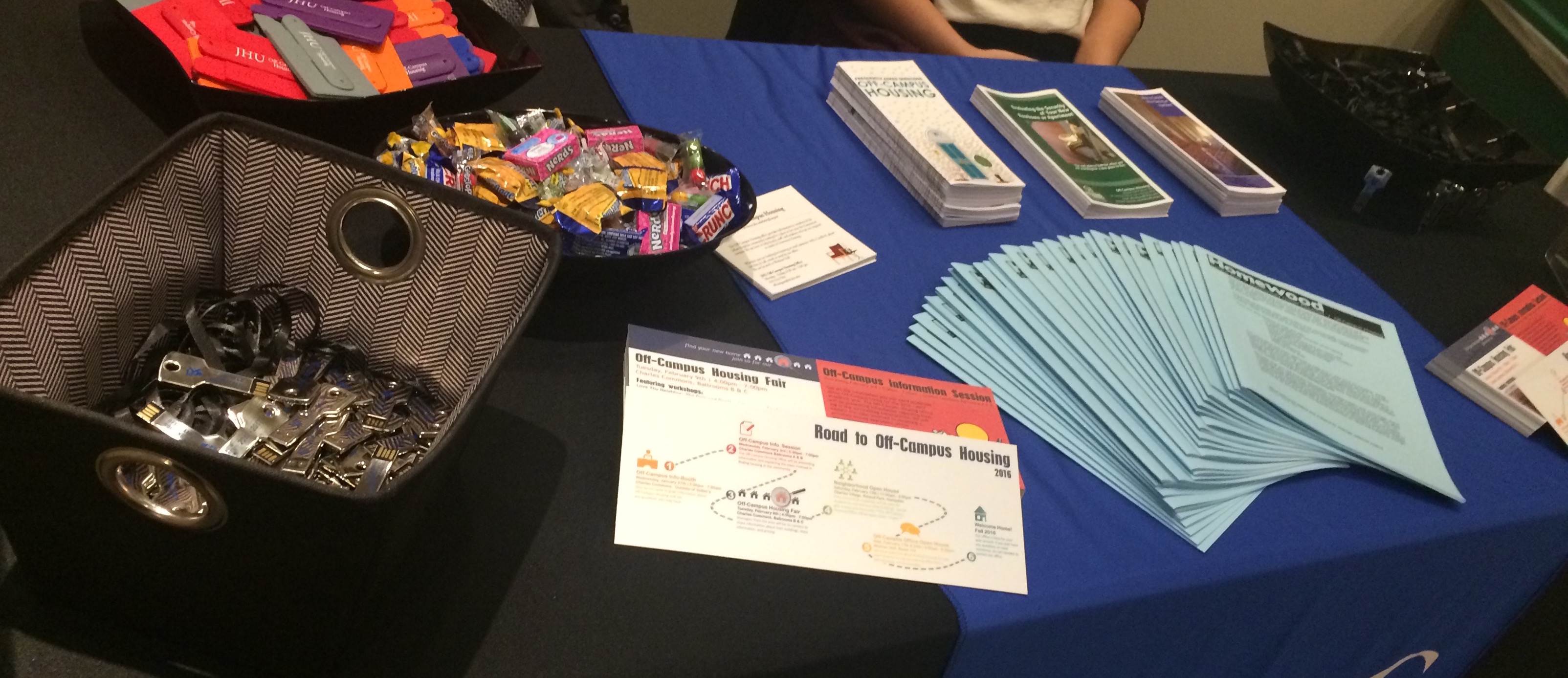 A table full of giveaways including various pamphlets and candy.
