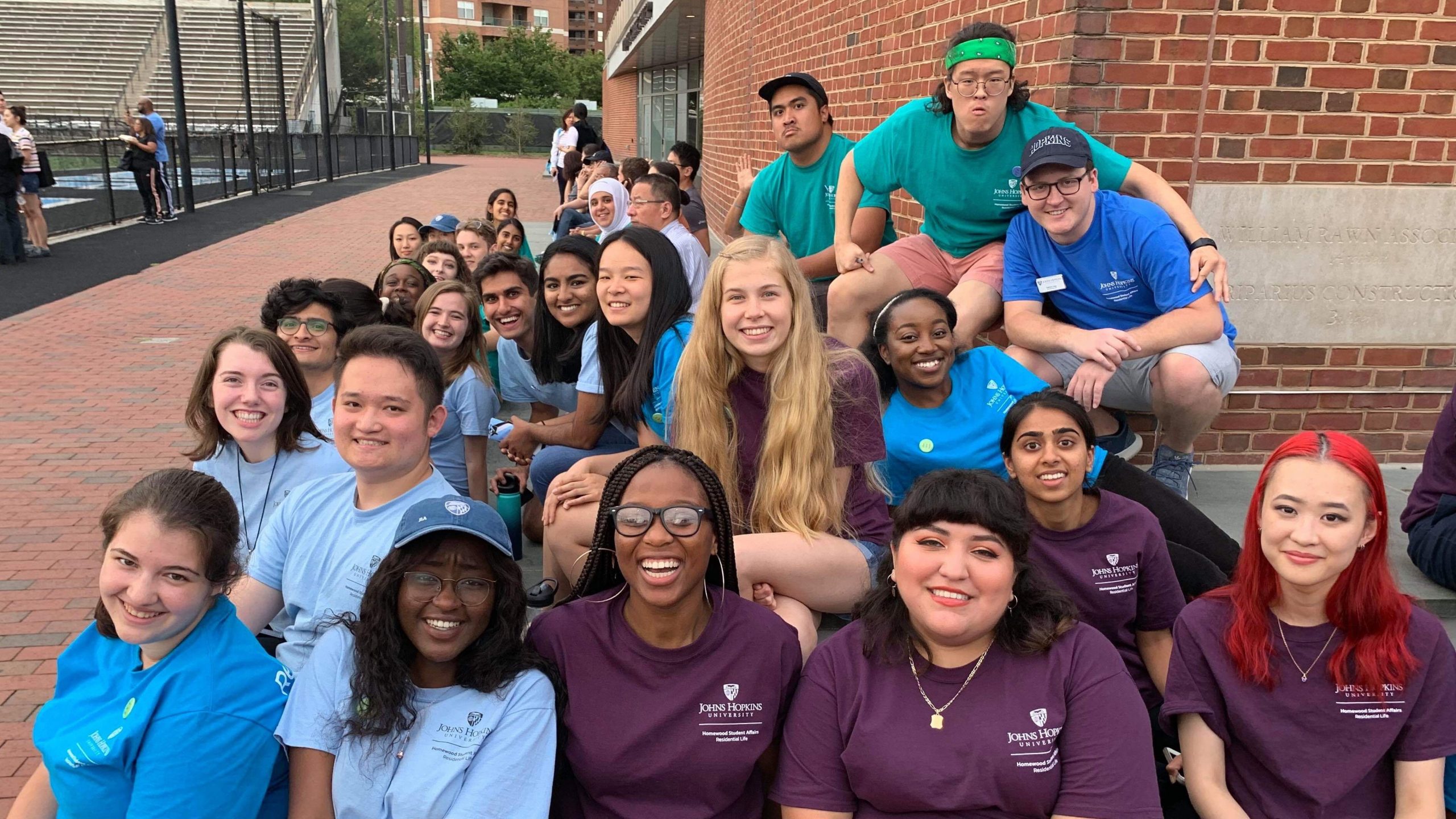 A group of students smiles on JHU's campus