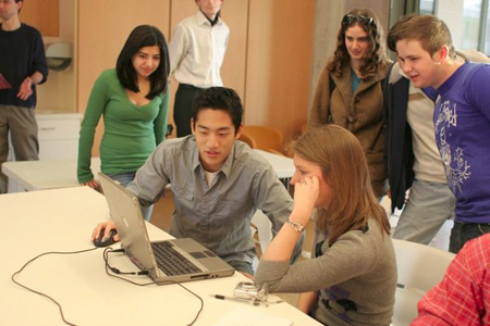 Students look at computer while learning to make facebook apps