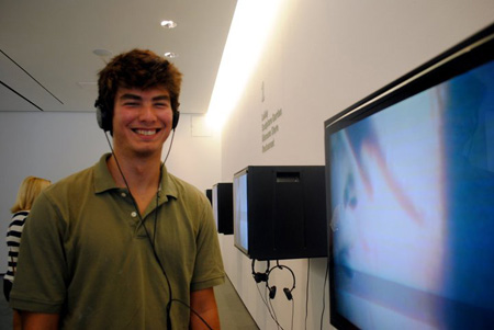 Filmmaker Jacob Appet stands next to monitor playing his film "Westbaum in High School"