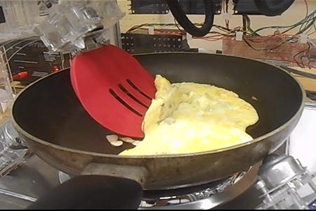 Robotic egg fryer flips cooked egg in skillet