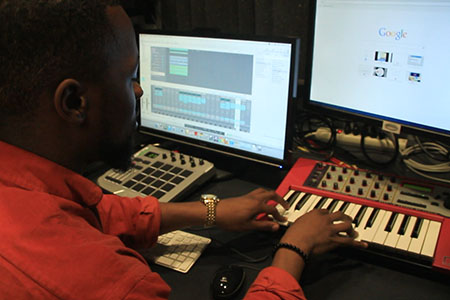 Alvin Onyewuenyi sitting at control station in DMC Audio Studio