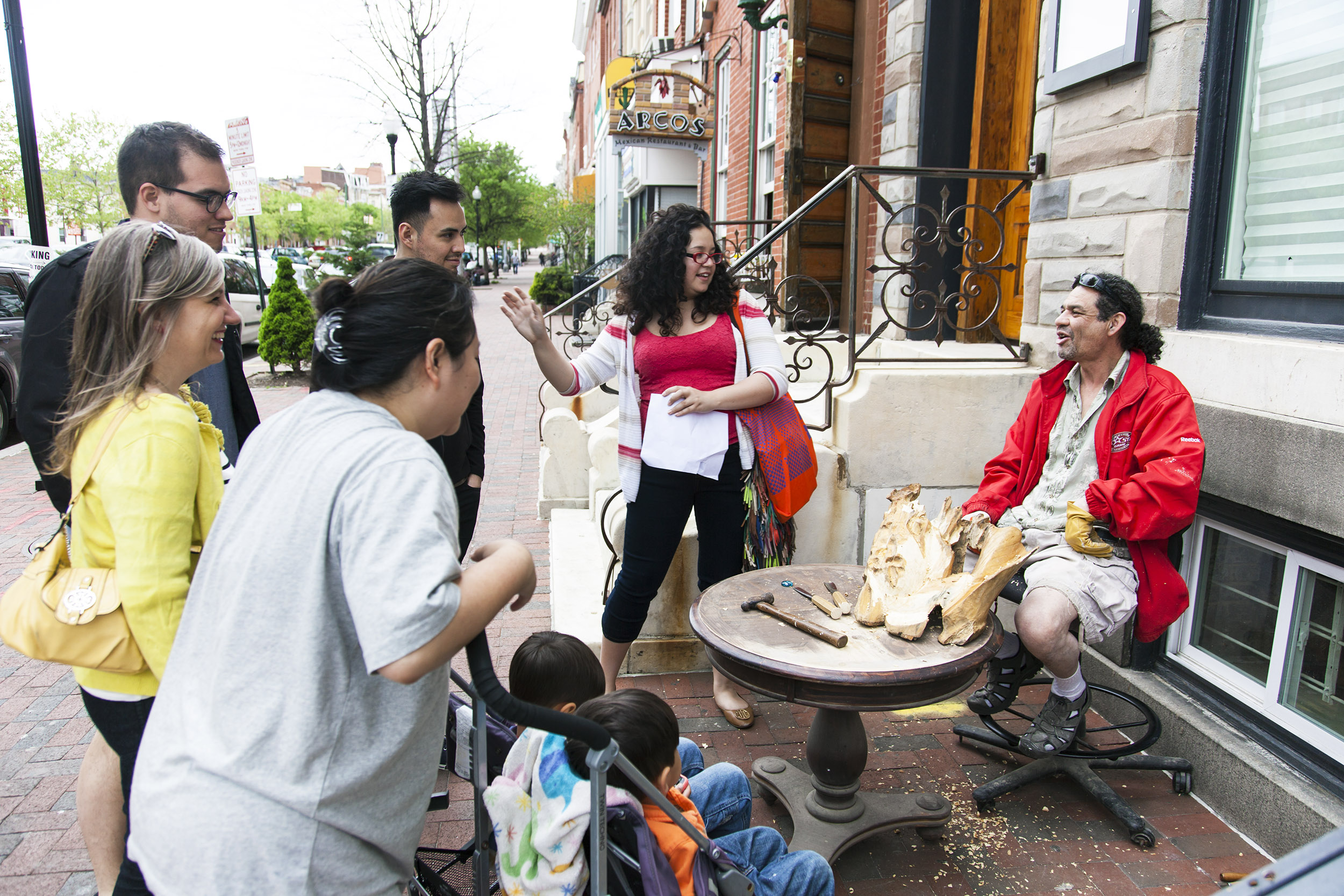Curator Michelle Gomez talks with neighbors during Devociones y Fe neighborhood walk