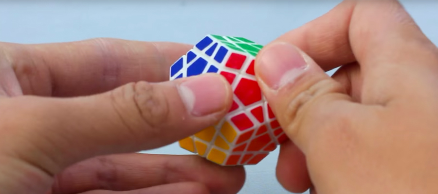 An extreme close-up of hands holding a twisty puzzle.