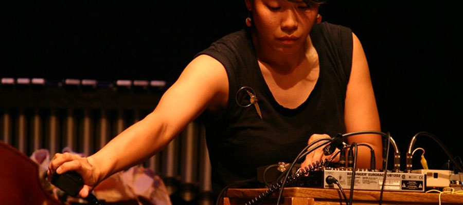 Bonnie Jones stands in front of equipment that helps her create electronic music.