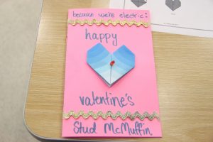 A handmade card that reads, "because we're electric: happy valentine's Stud McMuffin".