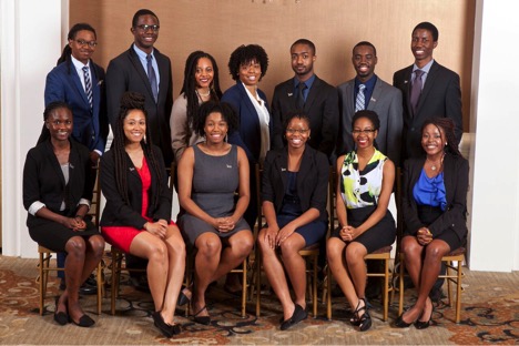 Dressed in business attire, men and women students pose for a formal group picture.