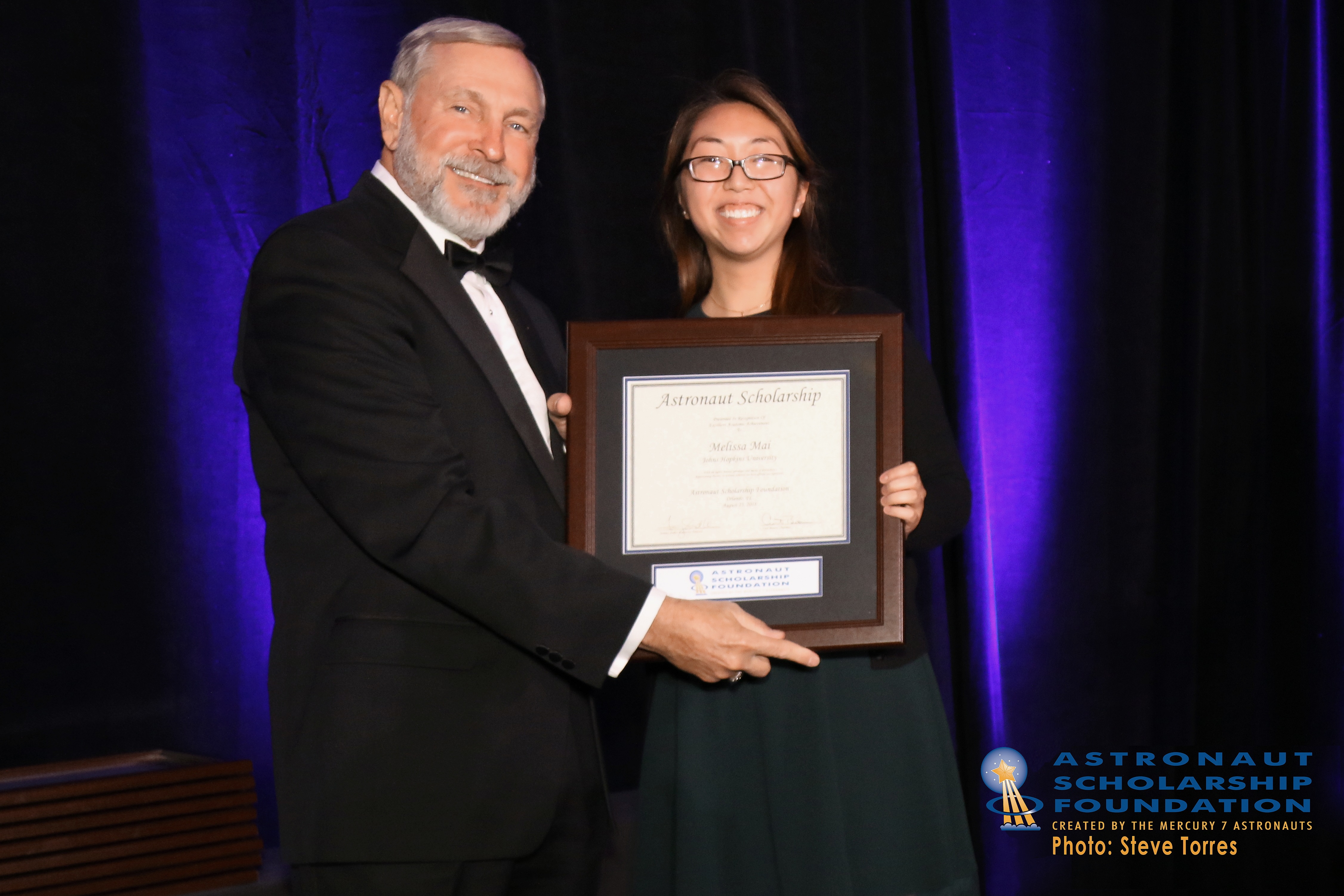 Melissa Mai receives her Astronaut Scholarship from Curt Brown at a formal event.