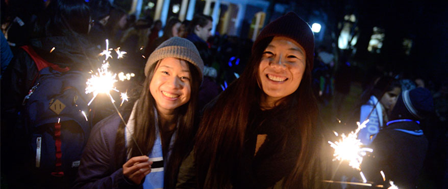 Students holding sparklers during a campus event.