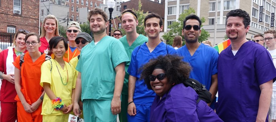 Pride parade - people wearing scrubs arranged in a rainbow order