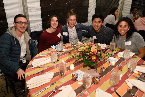 Five students sit around a table for ThanksGayVing 2018.