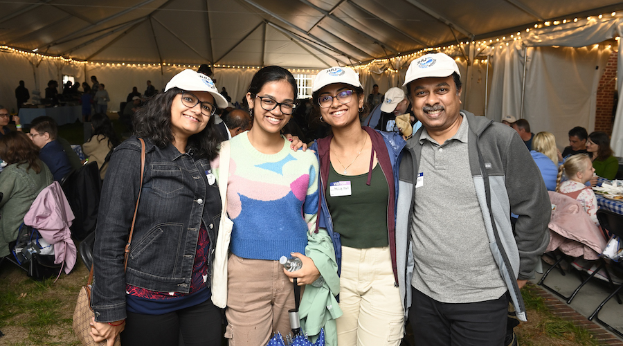 A student and her parents attend a reception during Family Weekend 2023