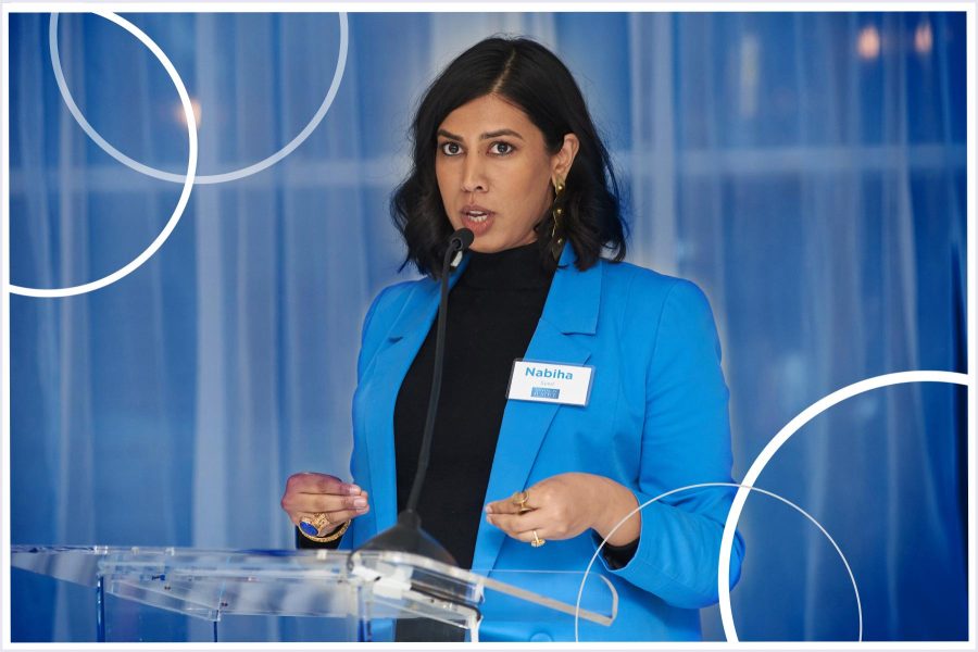 Nabiha Syed stands at a podium giving a speech.