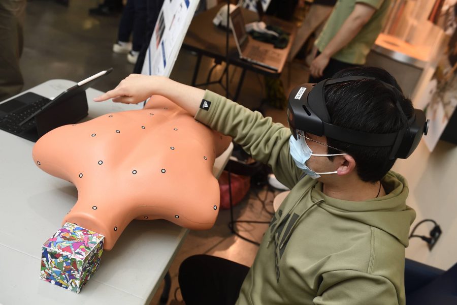 A student demonstrates an AR project with a body model.