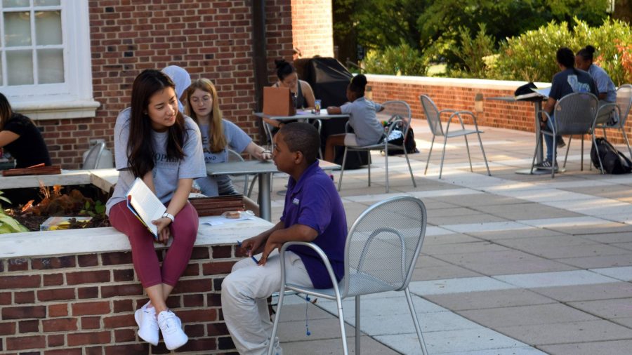 Students sit together with younger students during Tutorial Project.