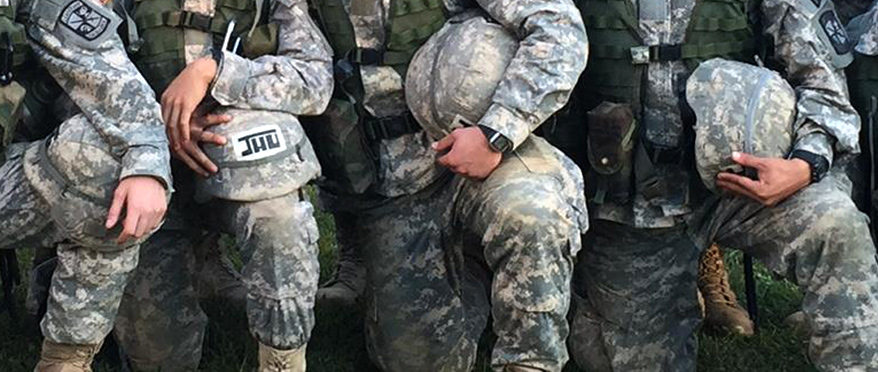 Students kneeling holding helmets