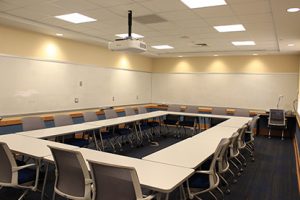 Empty Krieger Laverty Lounge classroom showing tables and chairs arranged in a rectangle. 