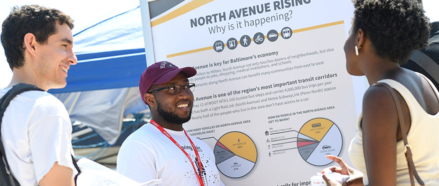 picture of CIIP intern working for the Maryland Transportation Authority and is speaking with some community members on the street