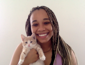Photo of Genesis Aire, smiling with a cat