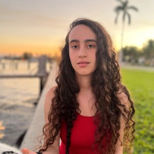 A photo of Siena DeFazio, one of the CIIP peer mentors, in front of a sunset