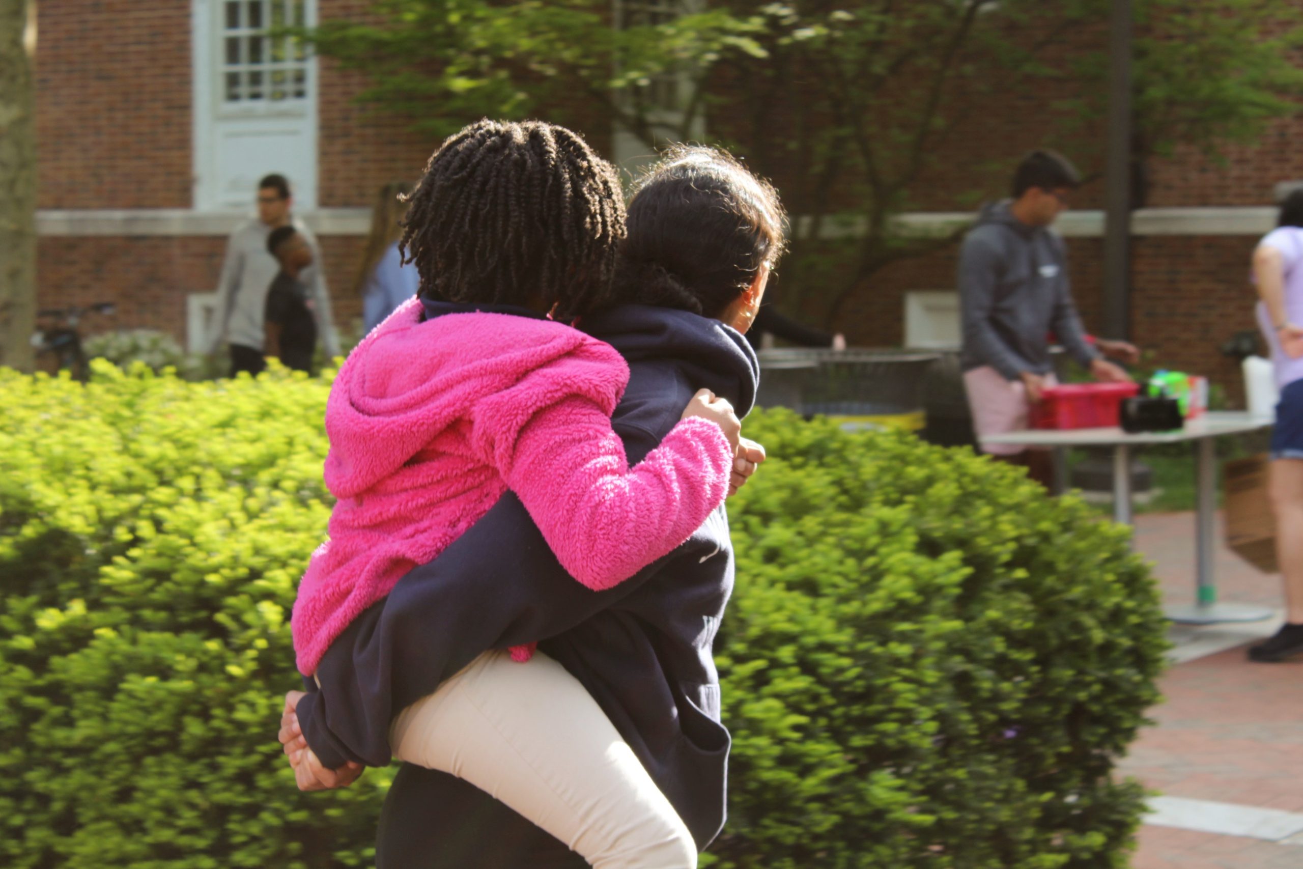 Tutor giving her tutee a piggyback ride at the 2023 field day