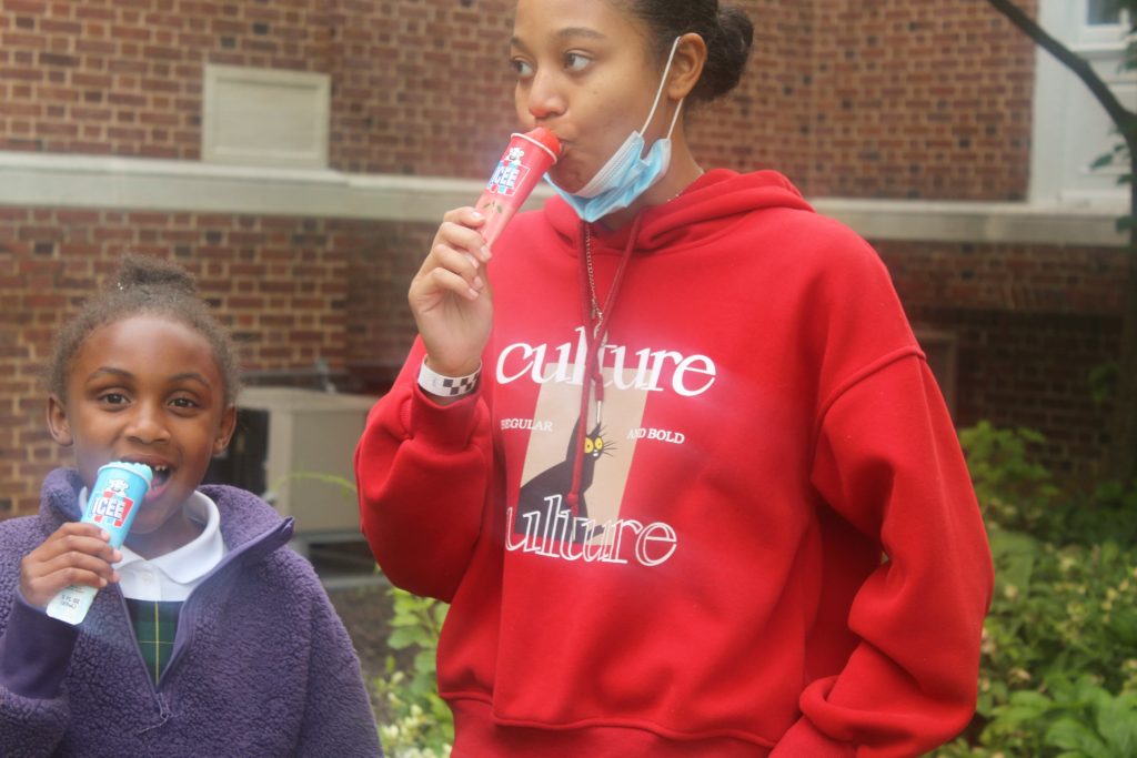 Student eating an ice pop at the 2023 field day