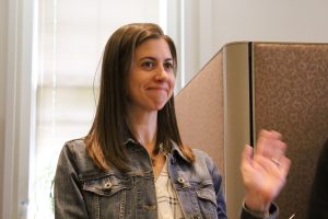 Alissa Murphy smiling and waving to the panel audience