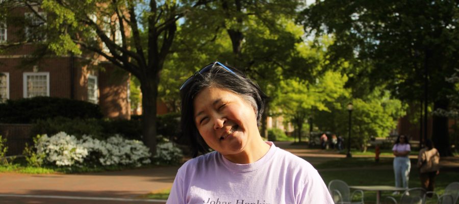 Young Song Smiling in a lavender t-shirt that says Johns Hopkins Tutorial Project