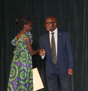 His Excellency Ambassador Jeff Gongoer Dowana shaking hands with one female participant