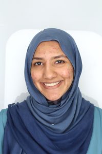 Headshot of Dua Hussain. She is wearing a blue hijab and smiling.