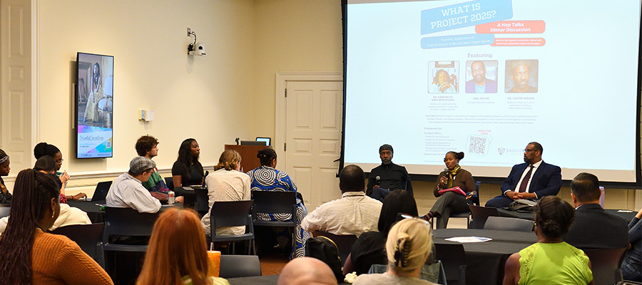 A room full of people attending a panel discussion