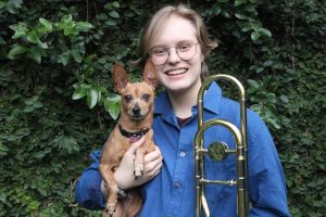 Deb George portrait of him smiling with trumpet and dog