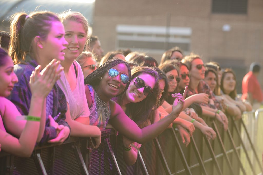 Concertgoers lean against the front barrier.
