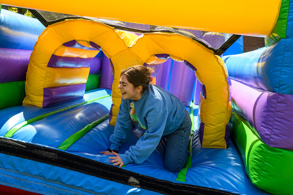 A student crawls out of an inflatable slide.