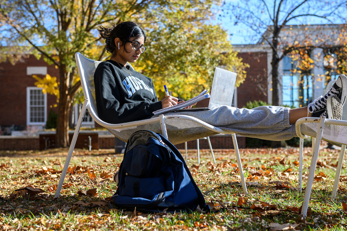 A student sits and works outside.
